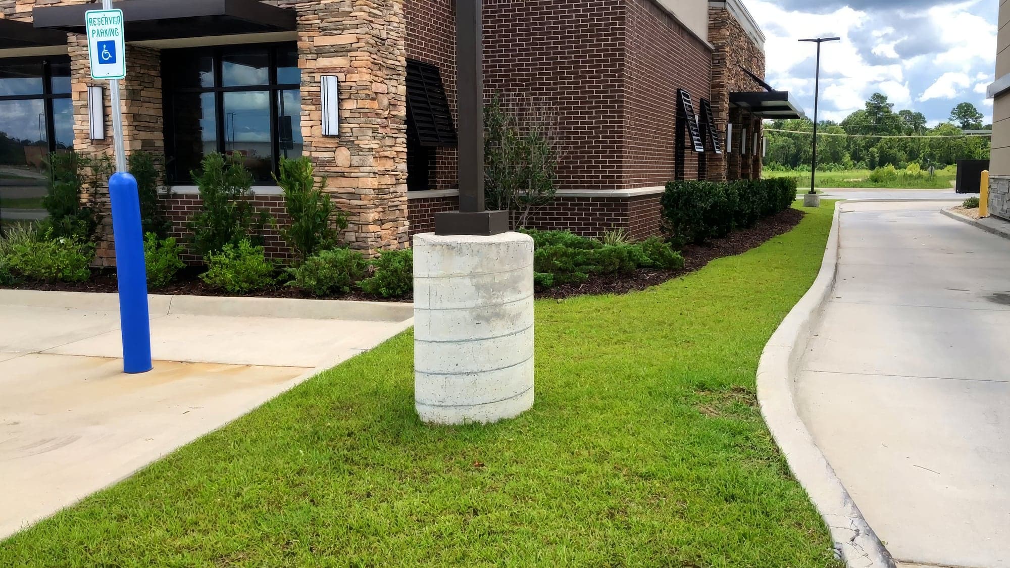 A freshly mowed lawn beside a brick commercial building