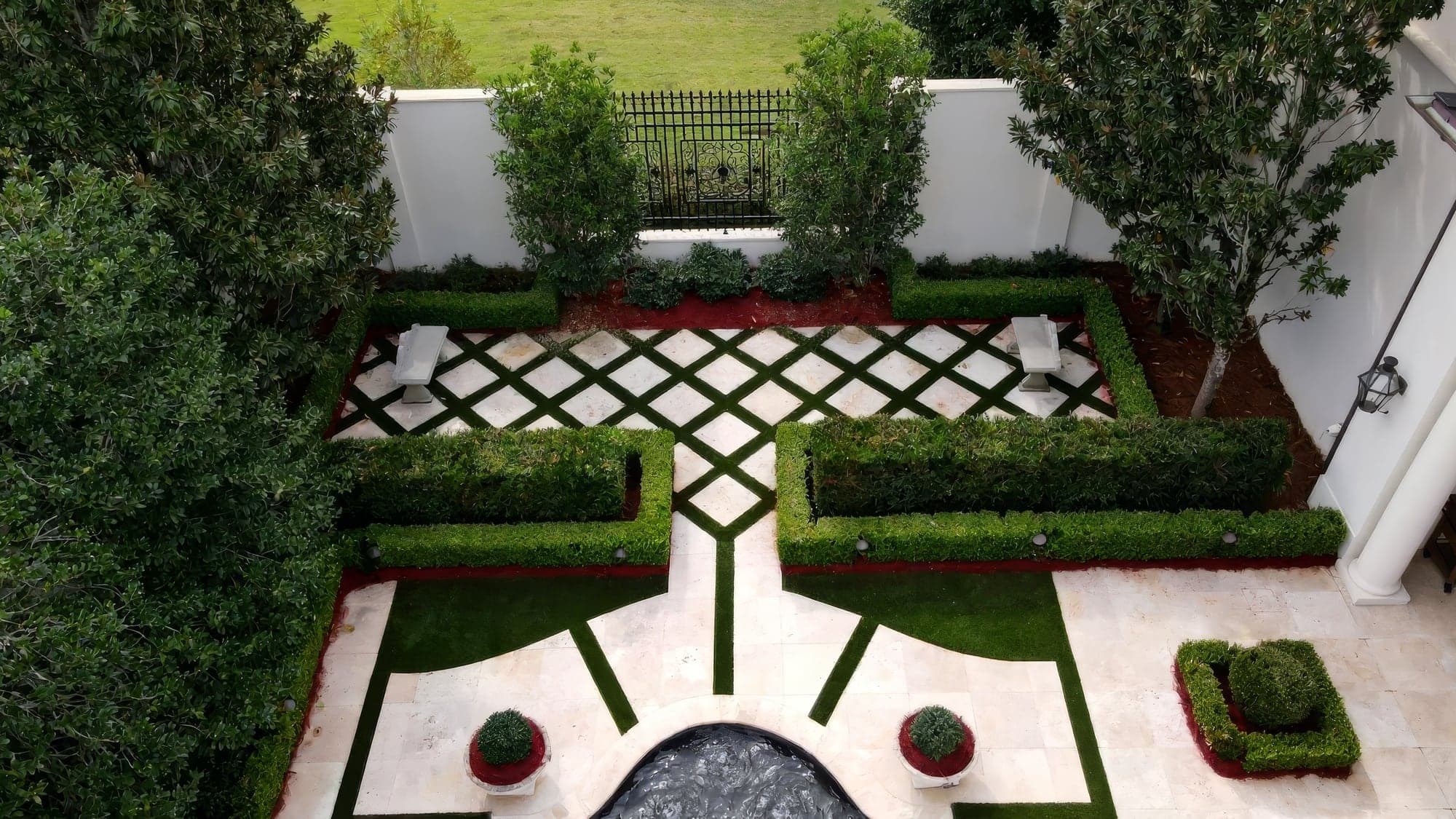 Aerial view of a courtyard with a diamond-pattern paver layout and artificial turf inlays