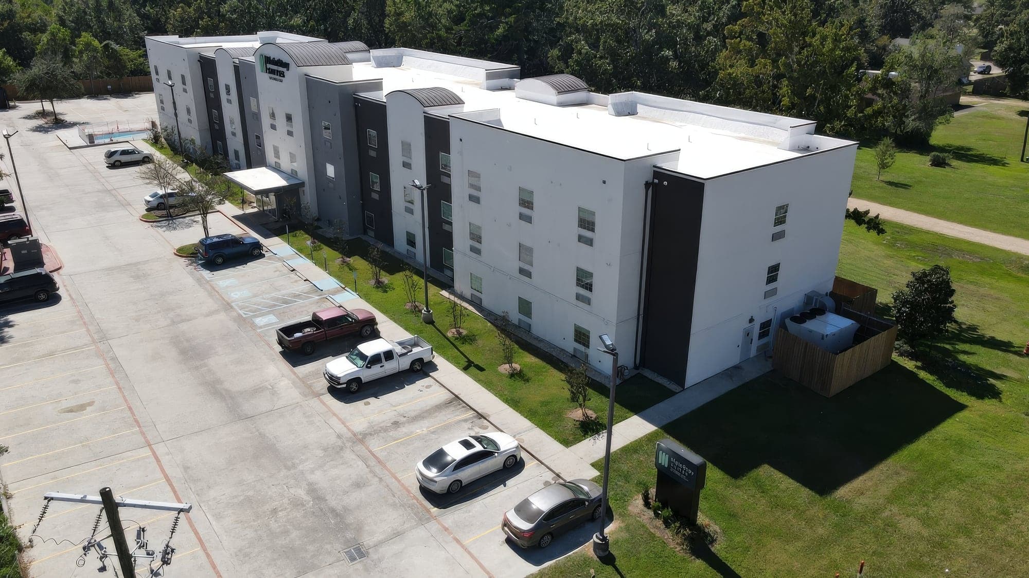 Aerial view of a three-story apartment complex with mowed lawns and parking maintained by Hernandez Lawnscape