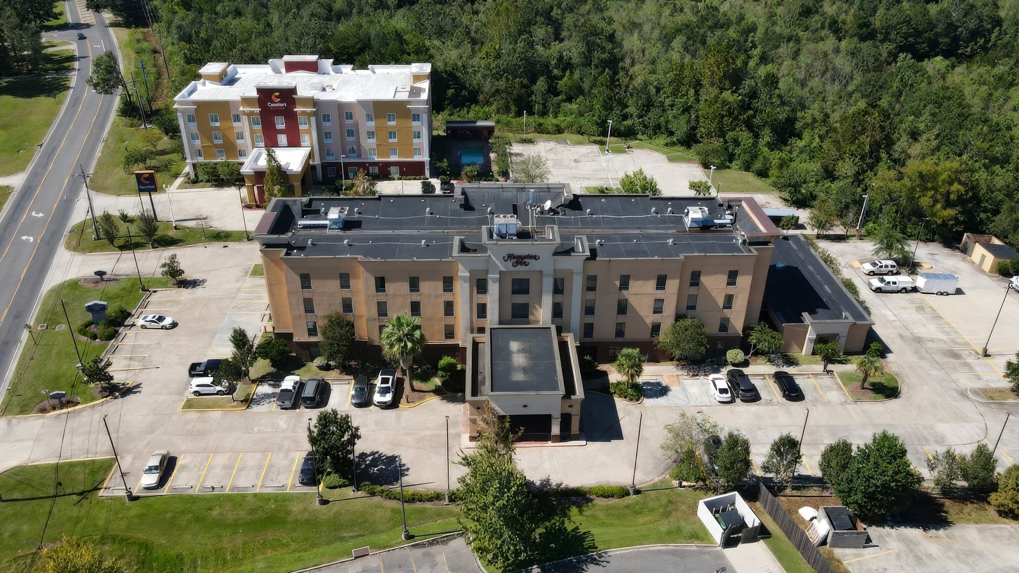 Aerial view of a hotel property with mowed grounds
