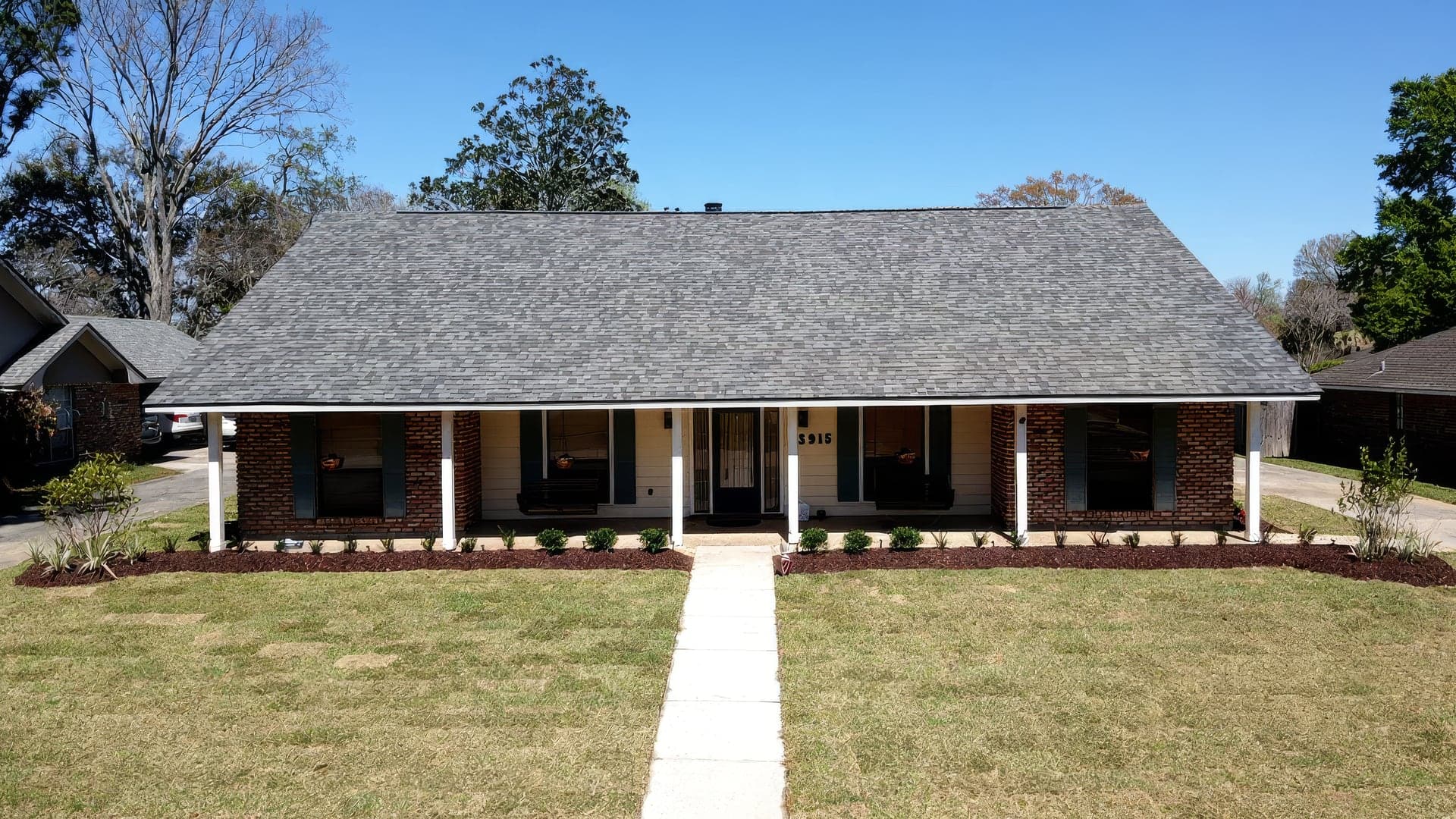 The same ranch home with fresh sod and new beds after the replacement