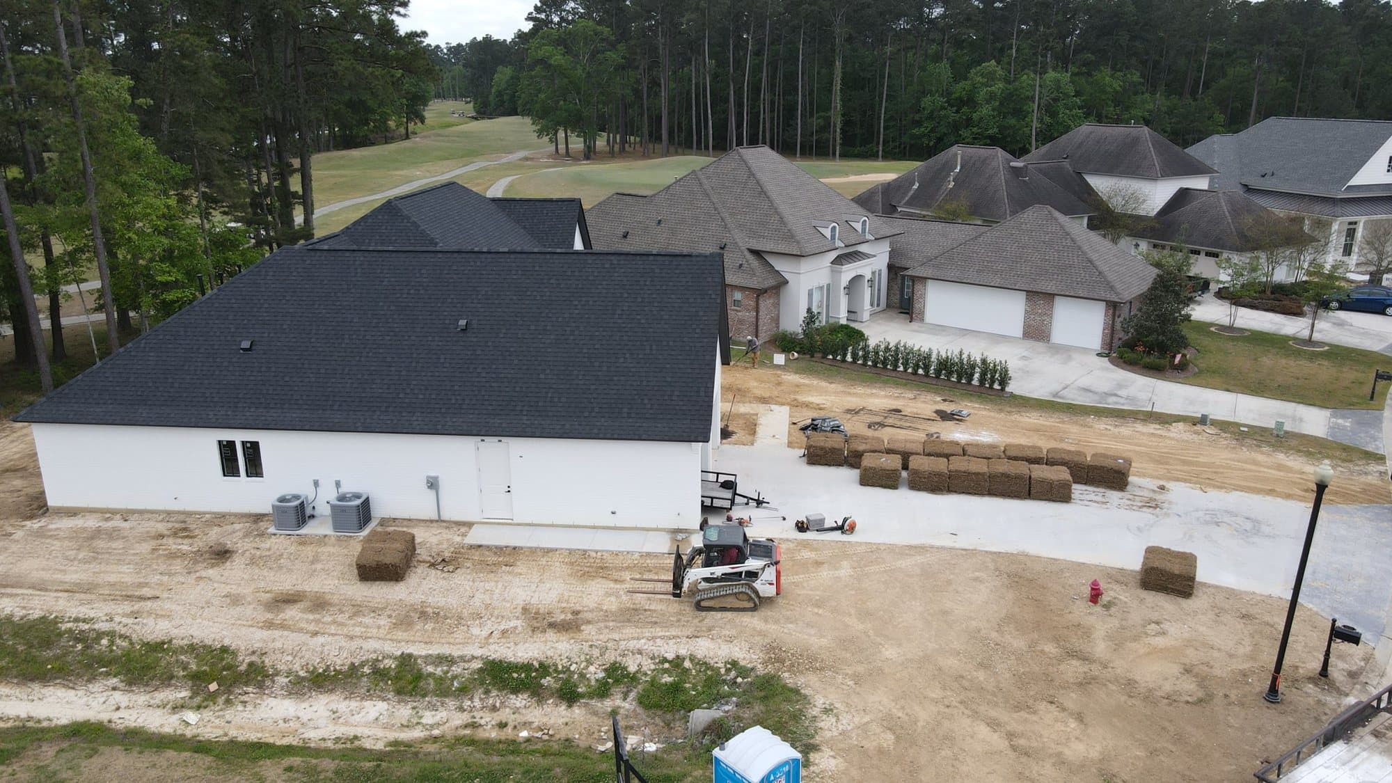 The rear of a new build with sod pallets and a compact loader